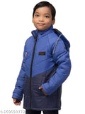 The image depicts a young boy standing against a plain background, wearing a bright blue coat with a hood. The coat has a zipper front closure and a distinctive emblem on the left chest area. The style of the jacket is trendy and modern
