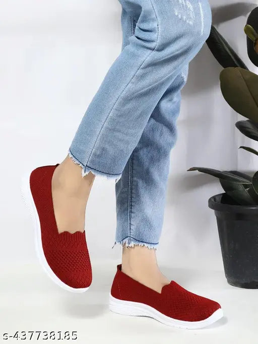 A red woven flat with a strap and zipper, styled on a mannequin
