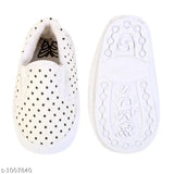 White children's boot with black polka dots and a star design, possibly soft material such as suede or velvet, designed in a simple slip-on style
