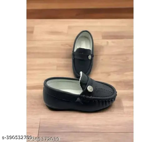 Trendy black shoe with velcro closure, displayed on a wooden floor