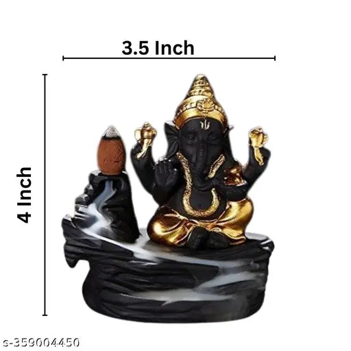 A gold-colored metal idol of Lord Ganesha, seated on a decorative base. The idol is intricately crafted and stands on a black marble surface. He holds a lotus flower in his lower right hand