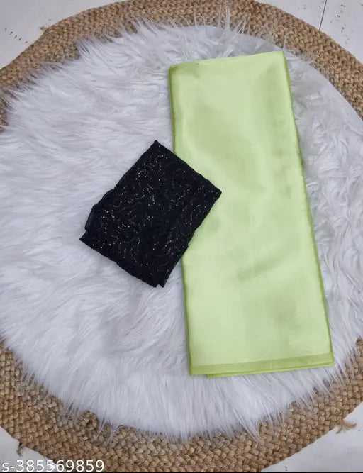 Green satin silk saree with sequence blouse, displayed on a rug.