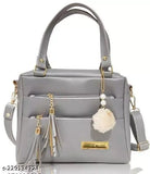 Silver purse with tassel, leather handle, and flap closure