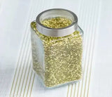 A round, transparent glass jar with a see-through cap, containing green glittery material and labeled as 1000 ml for storage in a kitchen pantry, suitable for storing flour, cereal, masala or dry fruits. (SKWAION Piramal Glass Jar 1000 ml Round Jars for Storage Kitchen Transparent Containers for Kitchen Pantry Flour Cereal Masala Dry Fruits See Through Cap Set of 6)