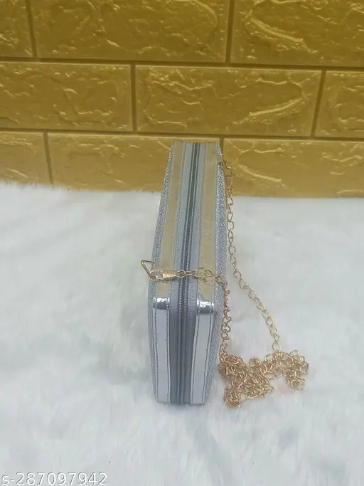 A silver clutch, possibly made of metal or faux leather, with a chain strap, spotted on a display table