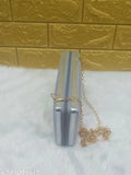 A silver clutch, possibly made of metal or faux leather, with a chain strap, spotted on a display table