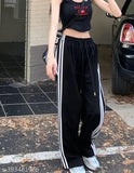Black athletic track pants with white stripes and a drawstring waist