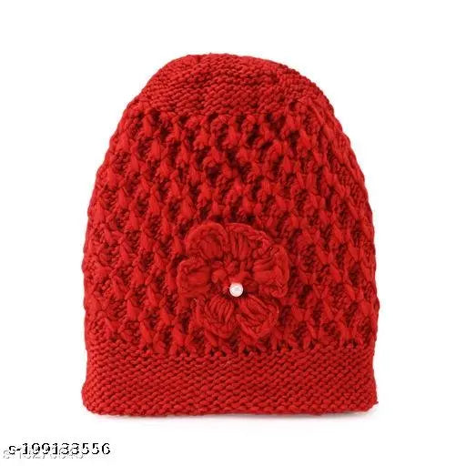 Red knit cap with flower appliqué, featuring a pompom and inside material, designed for unisex wear