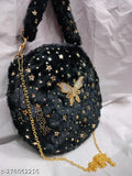The image features a small, dark blue shoulder bag with multiple decorative elements, including stars and what appears to be a gold butterfly charm. It has a visible strap suggesting it is designed for carrying on one's shoulder or as a baby sling. There is no text or countable items in the image