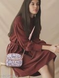 Woman wearing a red dress with a sling bag featuring two compartments