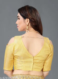 Yellow georgette saree with open back design, worn by a person at a festive occasion