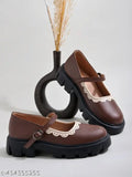 Brown synthetic round toe Mary Janes by Shoetopia, featuring a side buckle and white lace detailing. Great for women & girls