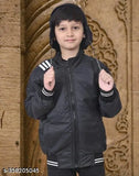 Black boy wearing a black jacket with white stripes on the sleeves, posing with hands on hips