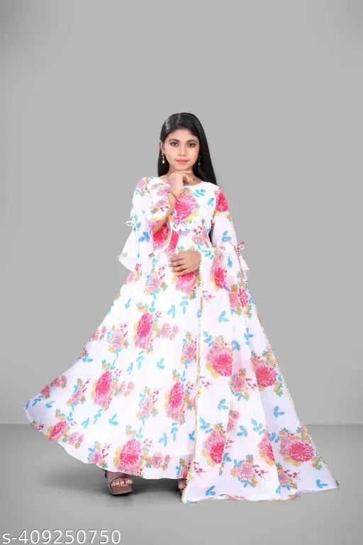 The image features a girl wearing a new, floral patterned gown. The dress appears to be designed for formal or special occasions, and is shown from a front perspective. It has a V-neckline with off-the-shoulder sleeves and a fitted waist with a pleated skirt. The color of the dress is predominantly white with floral patterns in shades of pink and blue