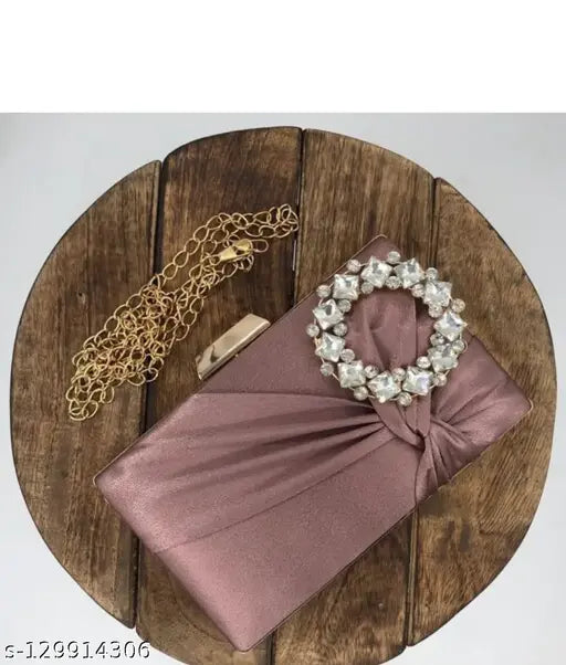 The image shows a large, elegant pink clutch with a bow, placed on a wooden surface