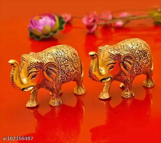 Metal decorative elephant statues set for home office gift. Two gold-colored metal elephants with intricate designs, standing side by side on a flat surface