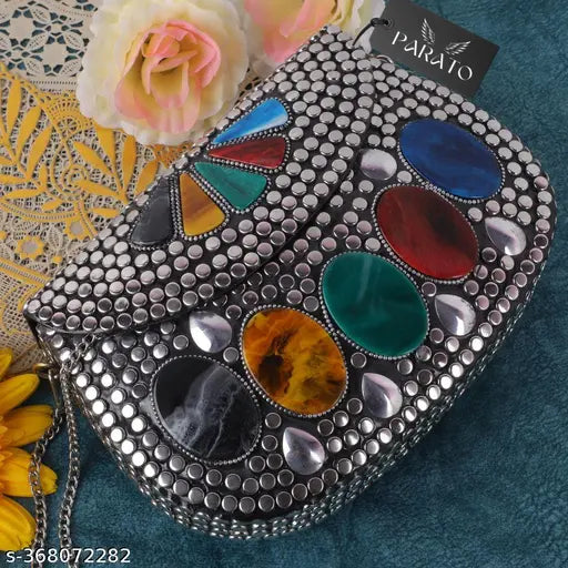 A silver metallic clutch purse with a variety of colorful stones, multiple compartments and a chain strap
