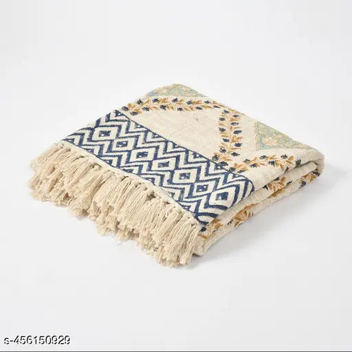 Multi-colored, multi-size, cotton throw or blanket with a fringed edge and patterned with a block print design