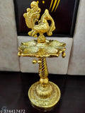 Golden Peacock designer metal diya stand, intricate Indian artwork, vibrant peacock design on display, net quantity 1, 10cm x 21cm dimensions
