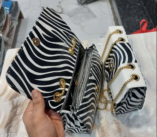 Black and white zebra print handbag with multiple pockets, strap closure
