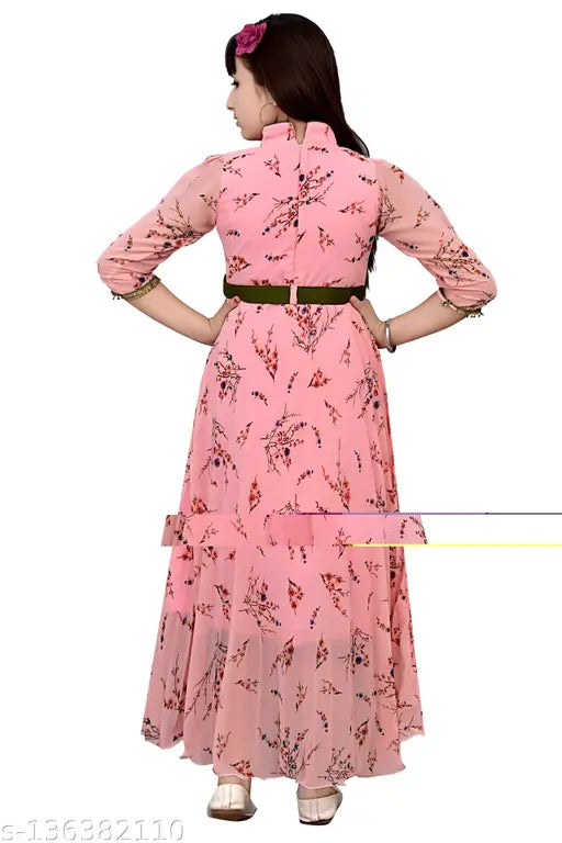 The image displays a long, pink dress with floral print, worn by a person who appears to be posing for the photo