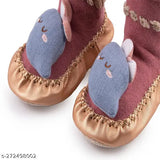 The image shows a pair of pink, soft children's shoes with blue trim and a light blue teddy bear motif. They have an anti-skid sole, are breathable, and designed for kids aged 6 months to 2 years