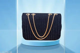 Fancy black sling bag with gold accents, crossbody style