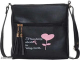 Black sling bag with pink heart design and zip closure