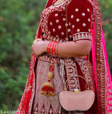 The image displays an elegant handcrafted evening clutch bag with a pink resin finish. It's a stylish partywear accessory, likely for women, with an apple-shaped design that features a flap closure. The handbag is adorned with tassels and has a spacious interior compartment suitable for holding essentials