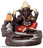 A colorful, decorative figurine of Lord Ganesh with a backdrop of a pond