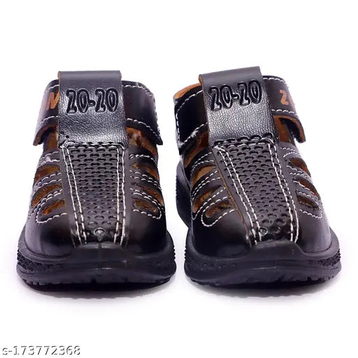 A pair of black closed-toe zoom sandals for kids, with a black strap featuring a textured design