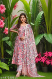 A woman in a vibrant floral patterned kurta set with a matching dupatta, posing outdoors
