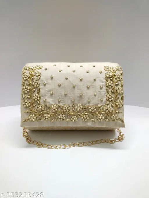 Handmade roll clutch with embroidered detailing and gold trim