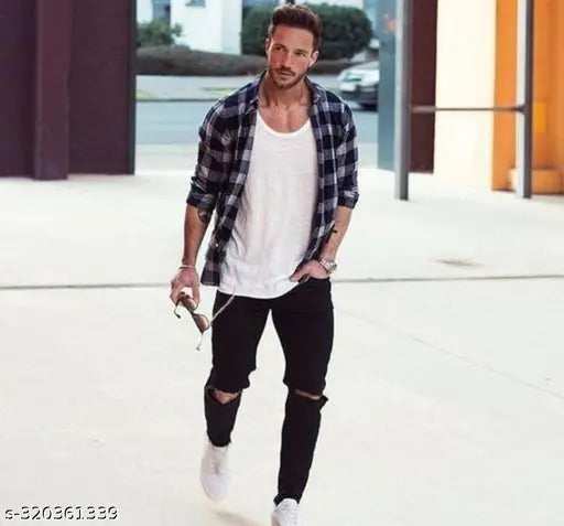 Black denim flaying men's knee-slit jeans, ripped and distressed on a mannequin