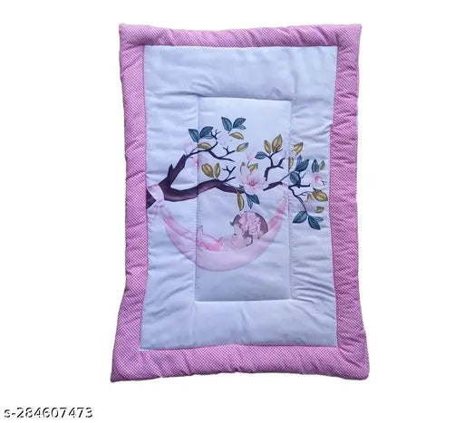 Newborn baby sleeping on a pink bed with tree and bird motif, pink cotton crib bedding
