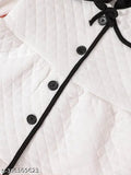 White winter coat with black trim and buttons