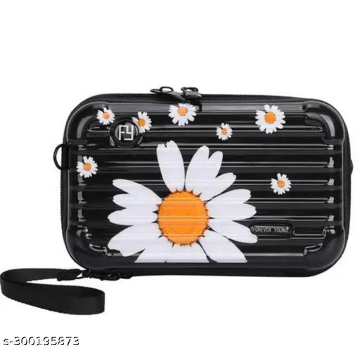 Mini suitcase with side belt, hand strap, and a floral daisy design on a black background. A small travel bag