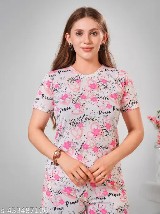Pink printed cotton blend night suit set for women, featuring a top with short sleeves and ankle-length bottoms with pockets, elasticated sides, and drawstring waist. Versatile for sleeping, lounging, traveling, yoga, gym, or parties. Made in India