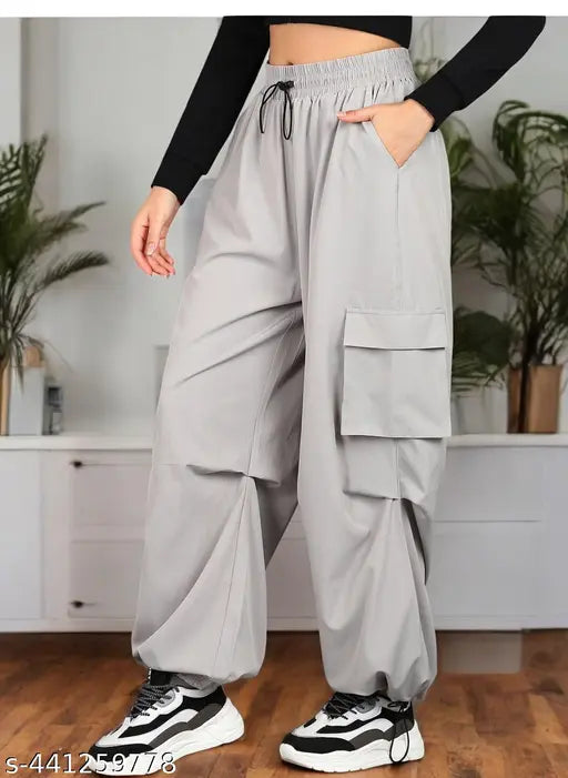 Multipocket cargo-style women's track pants in a neutral grey color, featuring multiple pockets, elastic waistband, baggy fit, and suitable for everyday and active wear