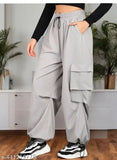 Multipocket cargo-style women's track pants in a neutral grey color, featuring multiple pockets, elastic waistband, baggy fit, and suitable for everyday and active wear