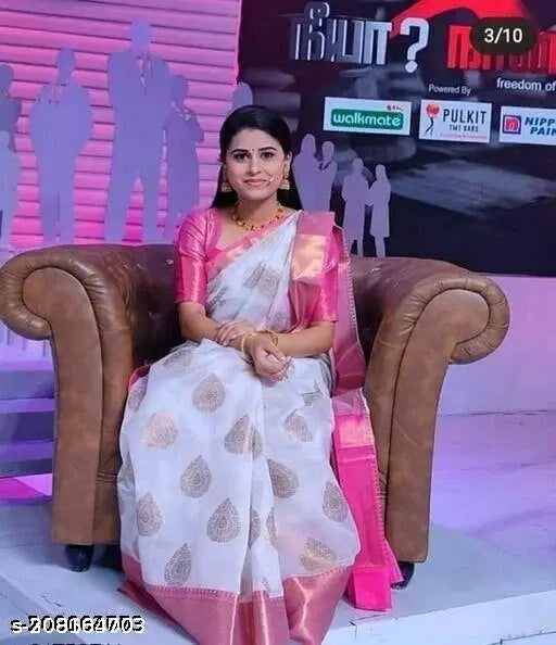 A woman in a vibrant Banarasi and chanderi silk saree with cotton pallu, sitting on a couch