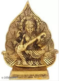 Antique golden metal figure of Hindu deity Saraswati, playing a string instrument, with a leaf backdrop. 13cm height