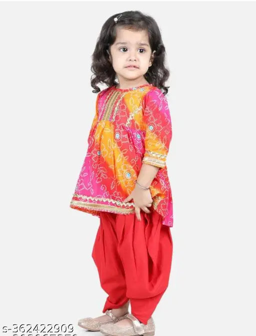 Red bandhani and lace embellished cotton rayon kurta and dhoti set with A-line top and dhoti pants, three-quarter sleeves, above knee length. Traditional Indian fashion for girls aged 1-8 years