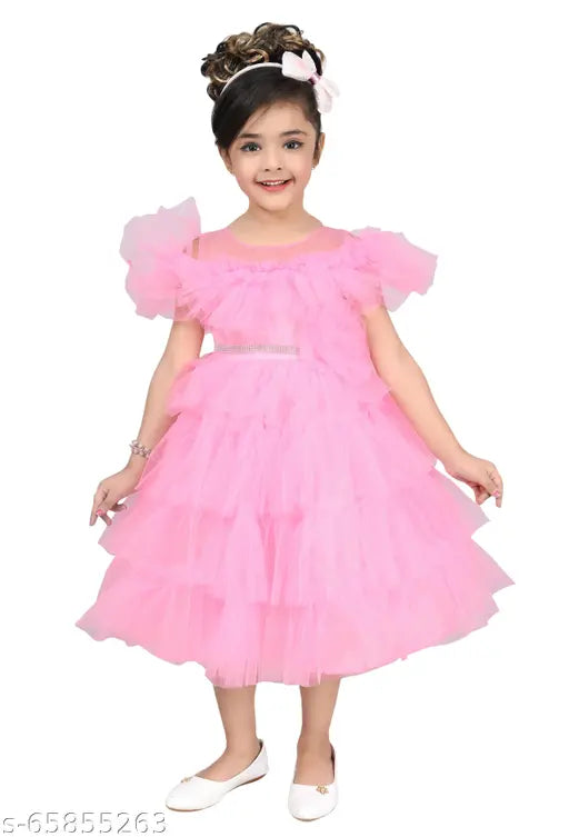The image depicts a young girl in a pink tulle party dress, featuring ruffled sleeves and a layered skirt