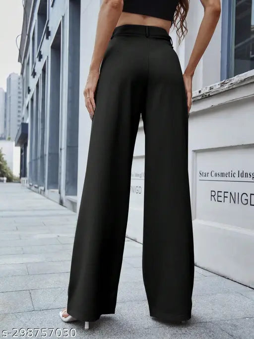 The visible attributes in the image include a person modeling pants, black pants with flared legs, and what appears to be a tall building or structure in the background
