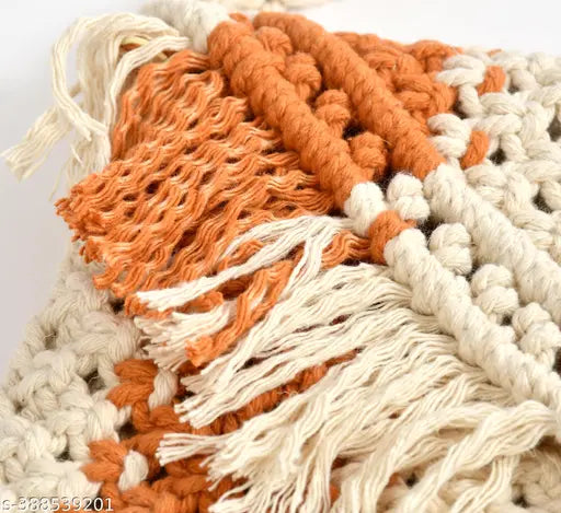 The image displays a handcrafted bag with beige fringe, featuring shades of orange and cream. It has multiple tassels on its surface
