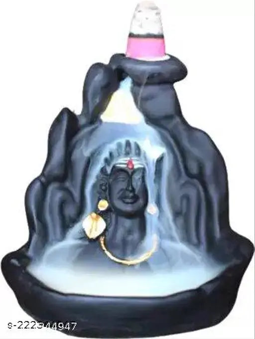 Black resin decorative showpiece of Lord Shiva, with blue-green stone background and a central seated figure of Lord Shiva in gold detailing