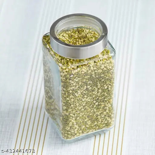 Transparent glass jar with lid, filled with green spices or herbs