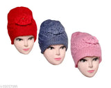 Pink, blue, and red knitted caps with pompoms on top