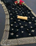 Black, mirrored fabric with intricate patterns and sequins on a traditional sari